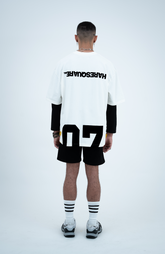 Model in the Haresquare White T-shirt with a Black print, styled with Haresquare Black shorts and designer sunglasses – unisex luxury sportswear from Ireland.